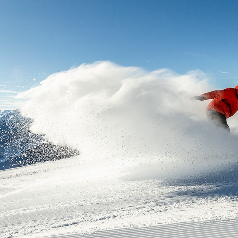 Skifahrer in Scuol auf sonniger Piste