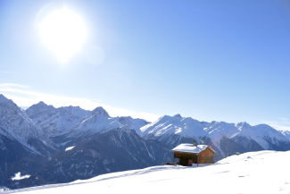 Hütte im Bergpanorama am Winterwanderweg