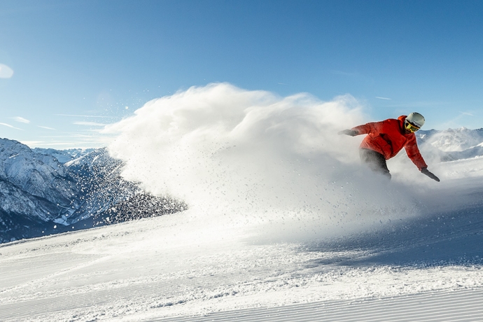 Skifahrer in Scuol auf sonniger Piste