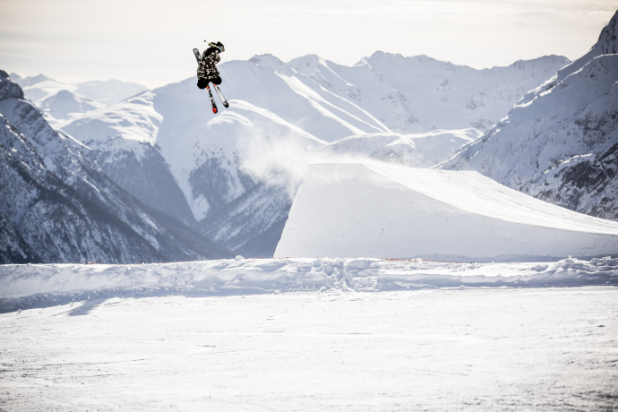 Skifahrer im Flug über Schanze bei Scuol