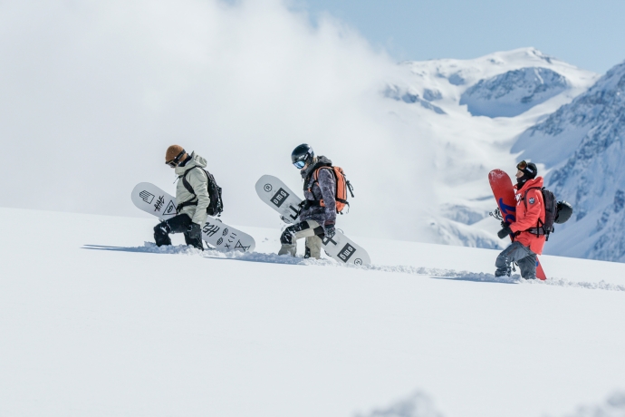 Snowboarder laufen durch Powder auf Motta Naluns